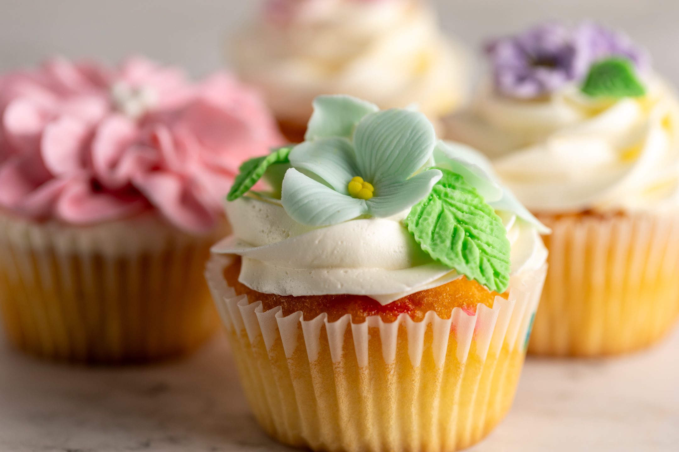 Sucré Handcrafted Floral Cupcakes — sculpted sugar flowers atop Italian meringue buttercream swirl