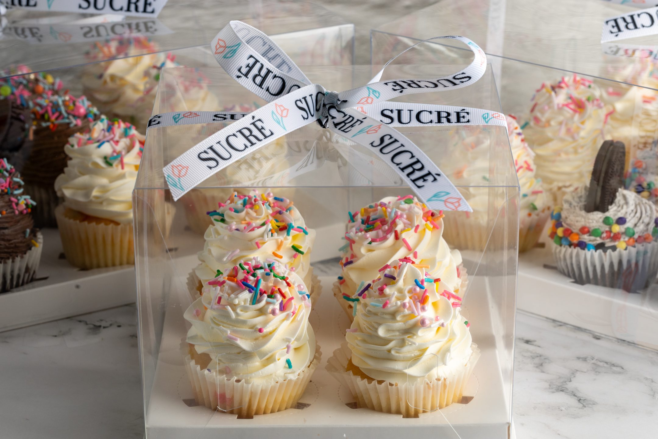 Sucré Buttercream Sprinkle Cupcakes — colourful sprinkle-topped Italian meringue buttercream cupcakes in celebration arrangement