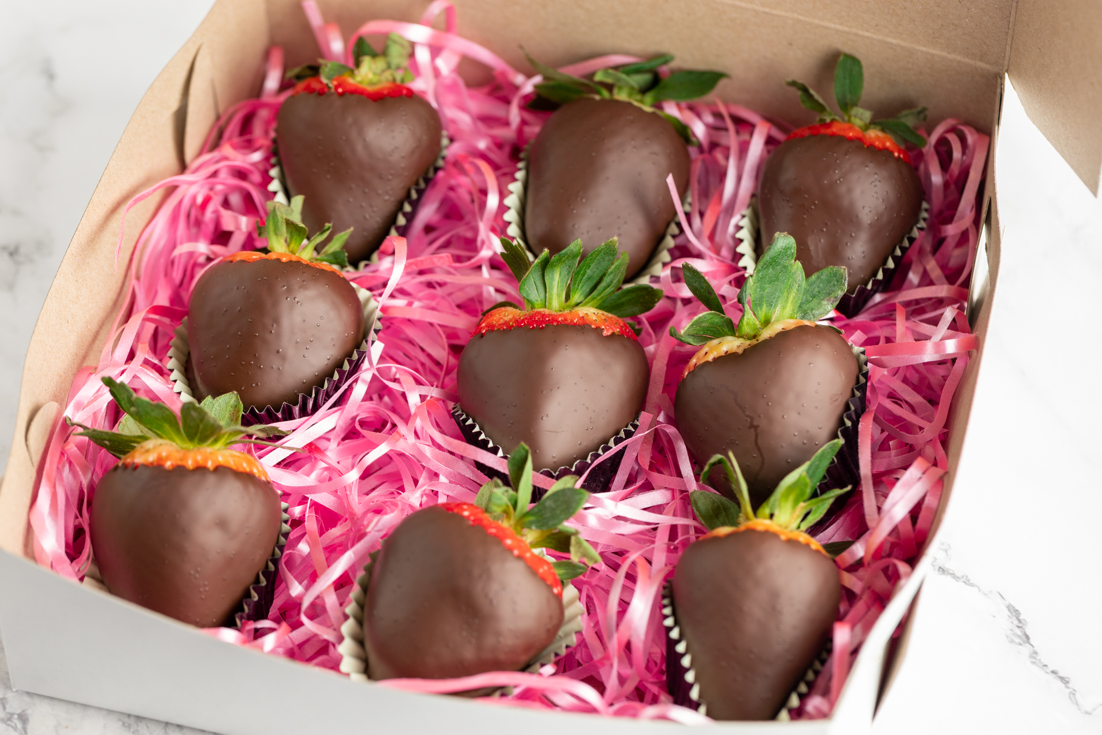 Belgian couverture chocolate strawberry bite revealing fresh fruit interior