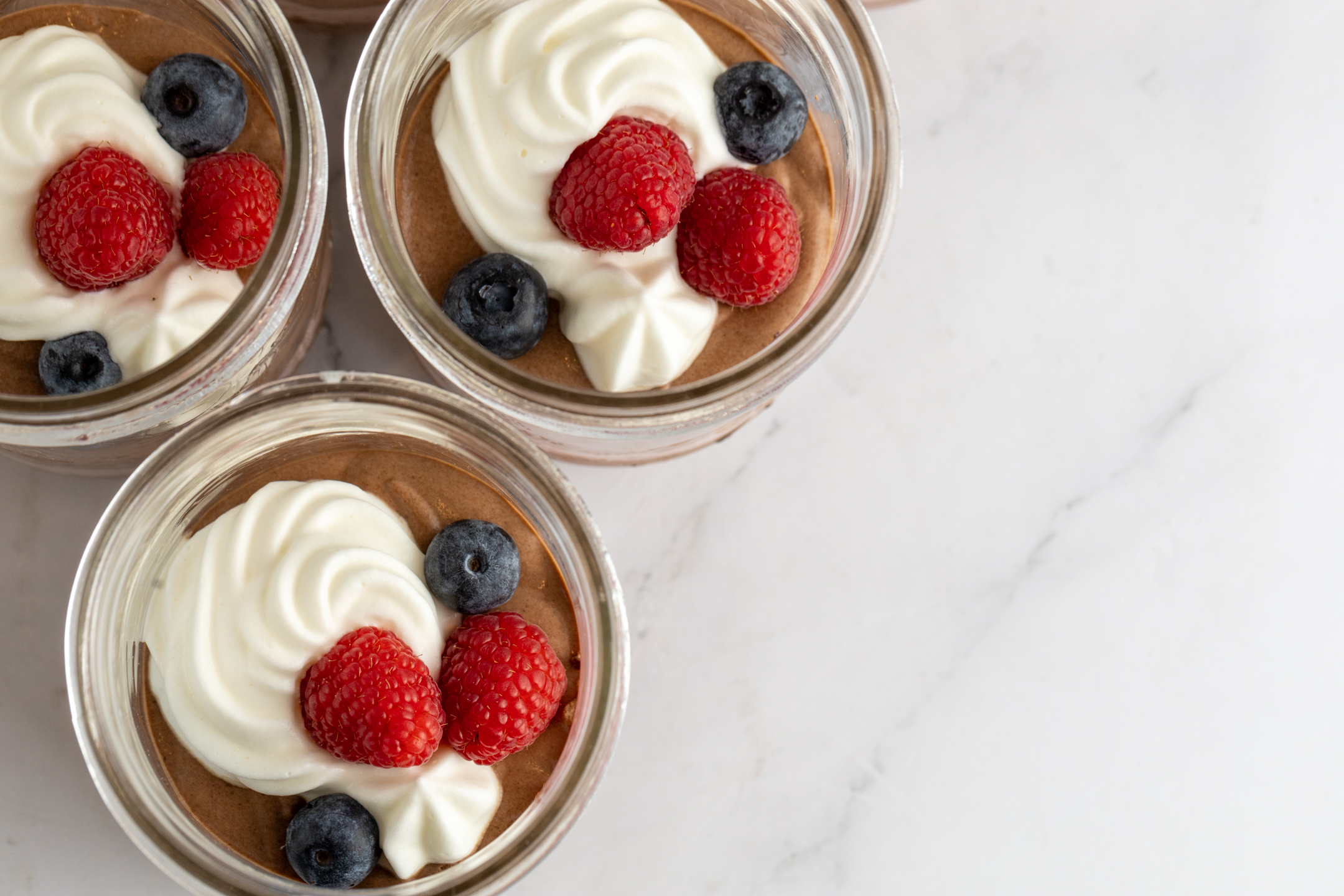 Belgian Couverture Chocolate Mousse in glass mason jar with Chantilly cream and fresh berries