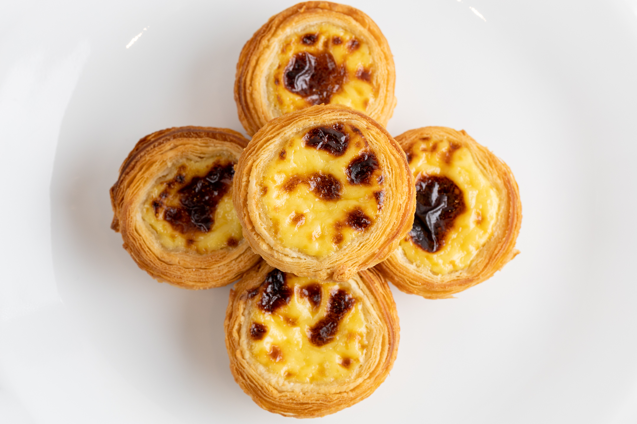 Close-up of Sucré Portuguese Tart showing caramelized custard and flaky all-butter crust