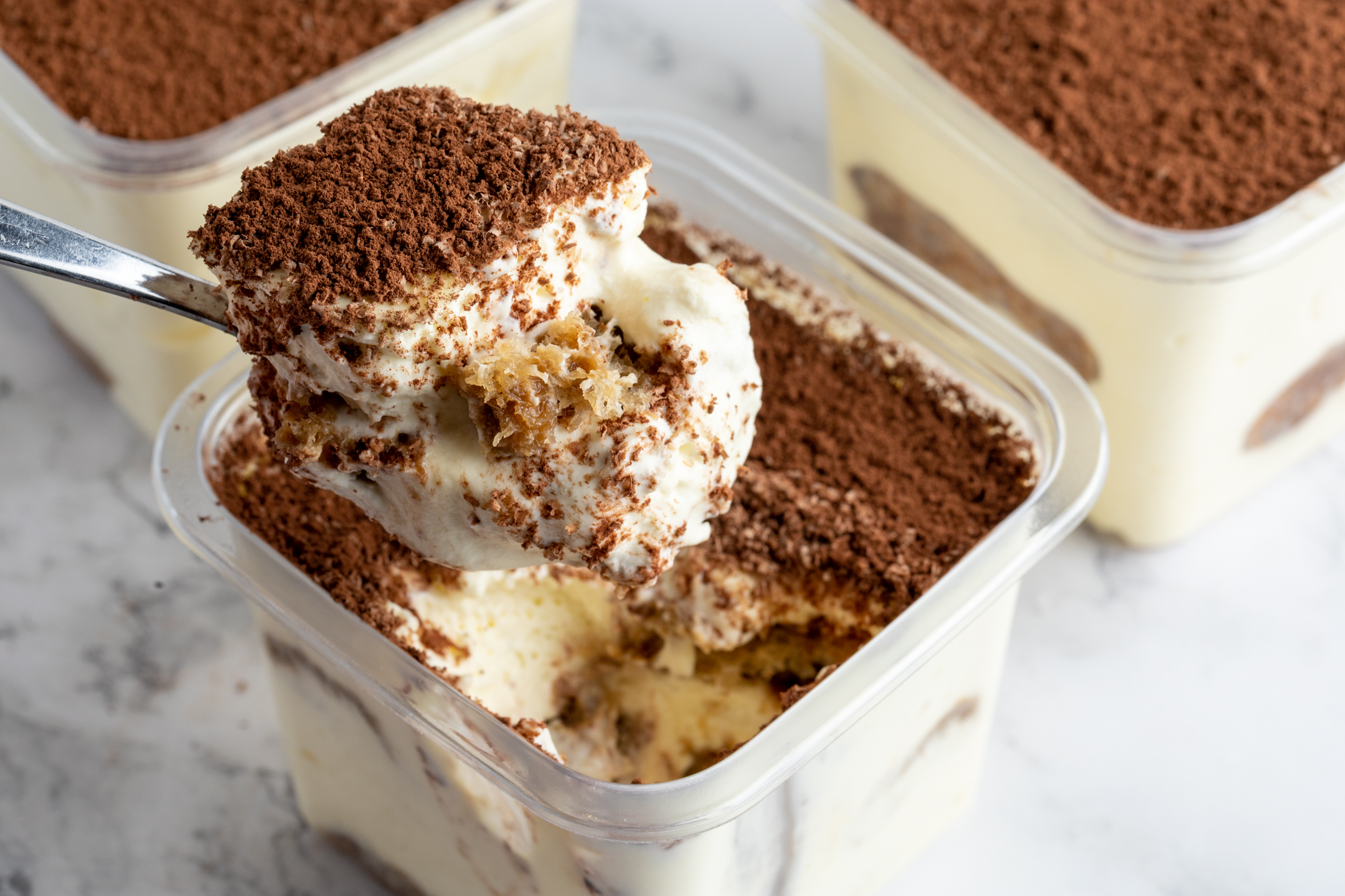 Sucré Tiramisu in 12 oz to-go container — espresso-soaked Savoiardi layered with mascarpone and Belgian chocolate shavings