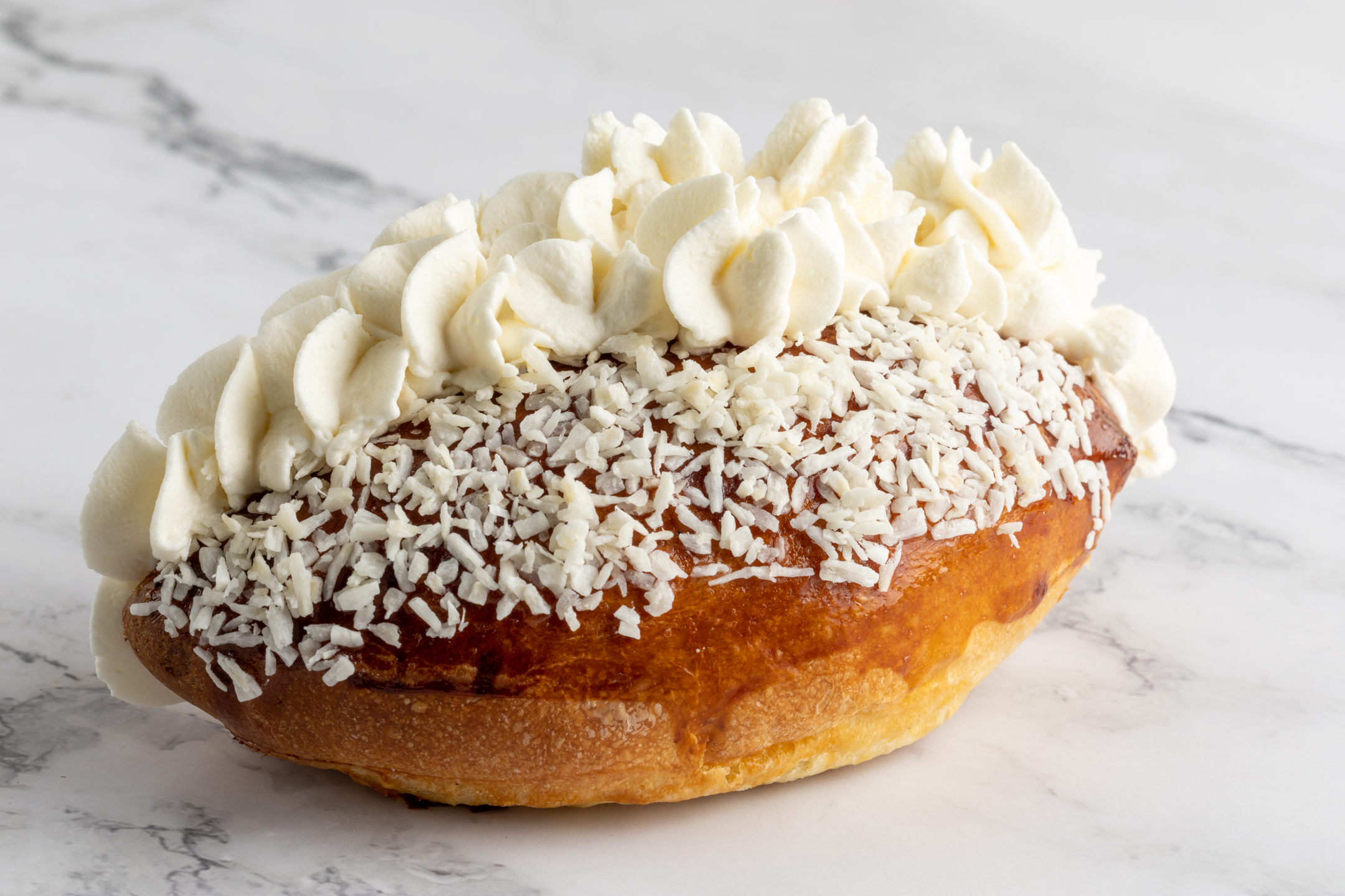 Coconut Cream Bun by Sucré — fluffy bun filled with pure vanilla Chantilly cream topped with shredded coconut