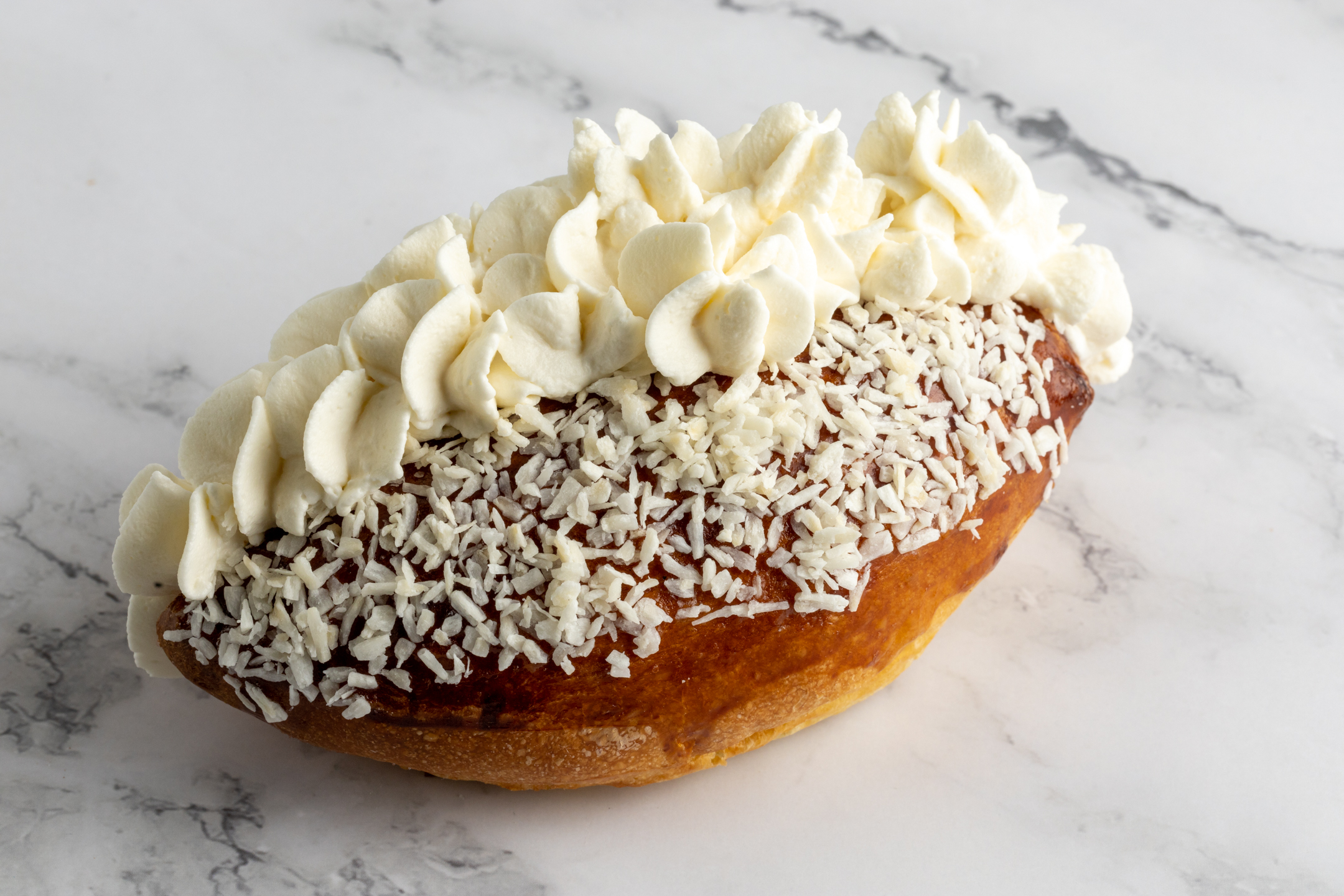 Coconut Cream Bun close-up showing shredded coconut topping and cream filling