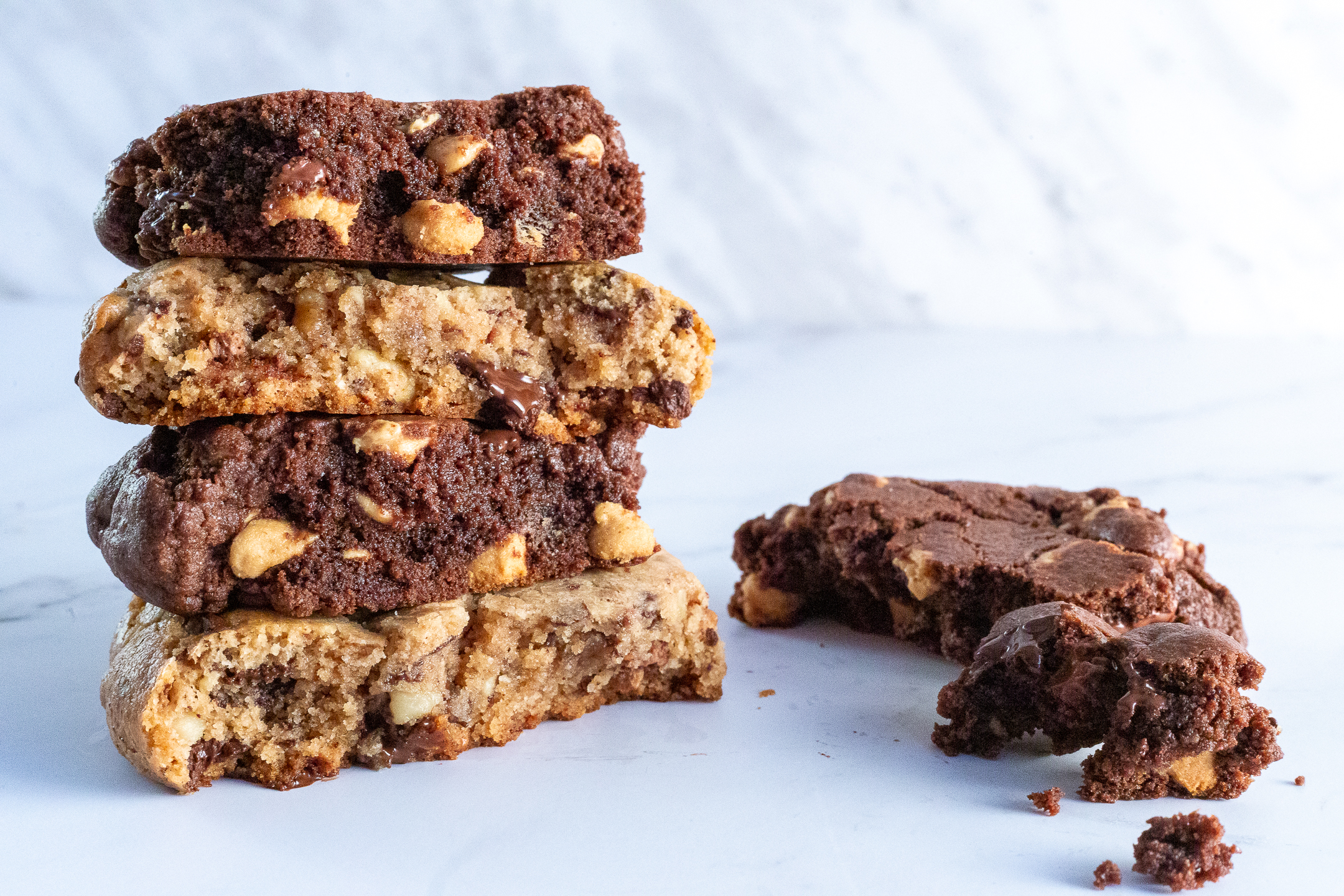 Stacked quarter pound cookies by Sucré showing thickness and gooey chocolate interior