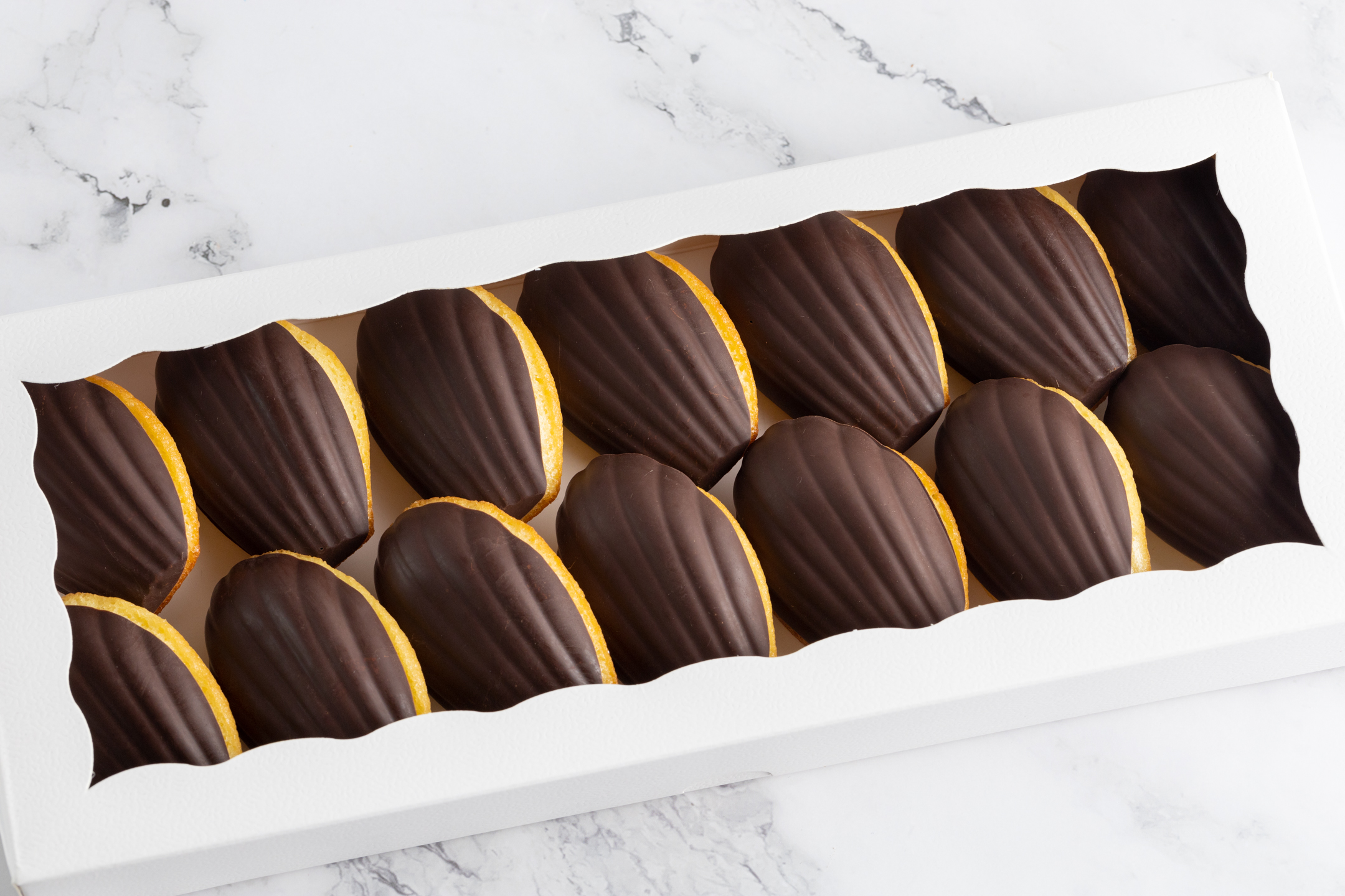Belgian couverture chocolate-coated Madeleine showing classic shell shape