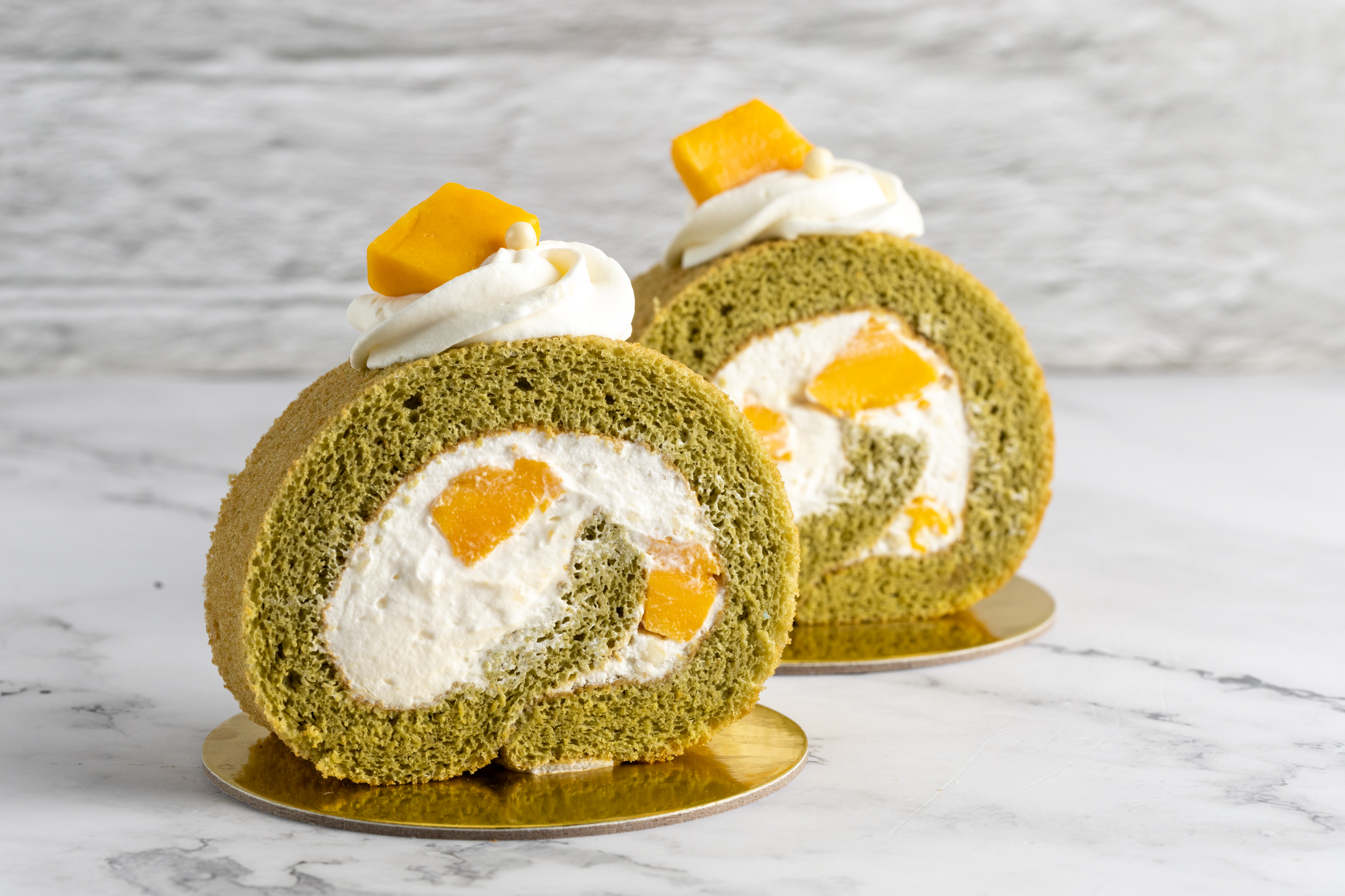 Mango Matcha Swiss Roll slice by Sucré — delicate matcha sponge with vanilla Chantilly cream and fresh mango