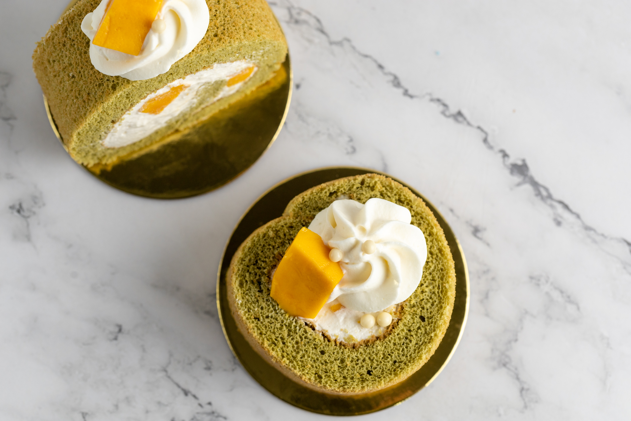 Mango Matcha Swiss Roll close-up showing matcha sponge and mango filling detail