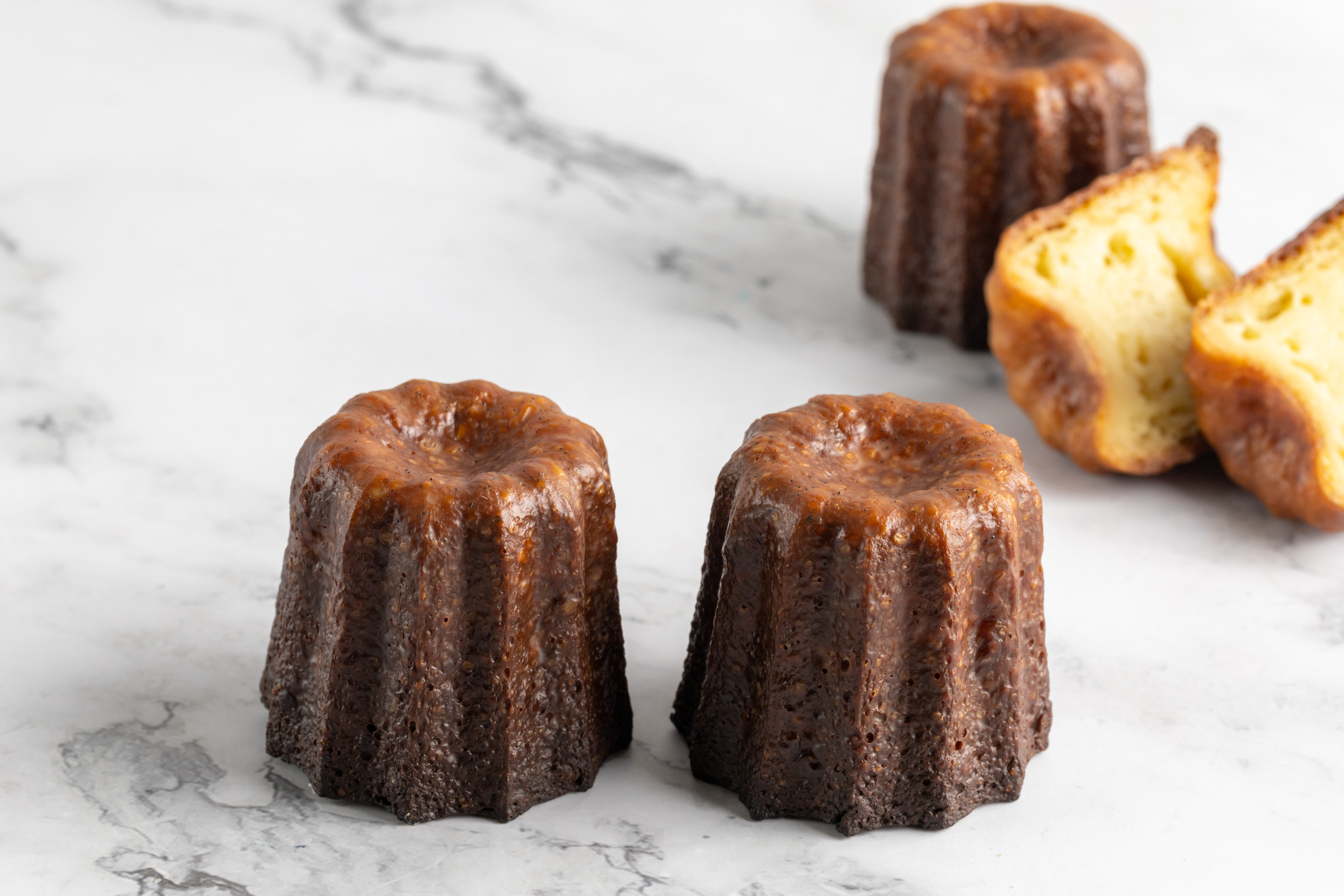 Canelés de Bordeaux cross-section showing creamy custard interior