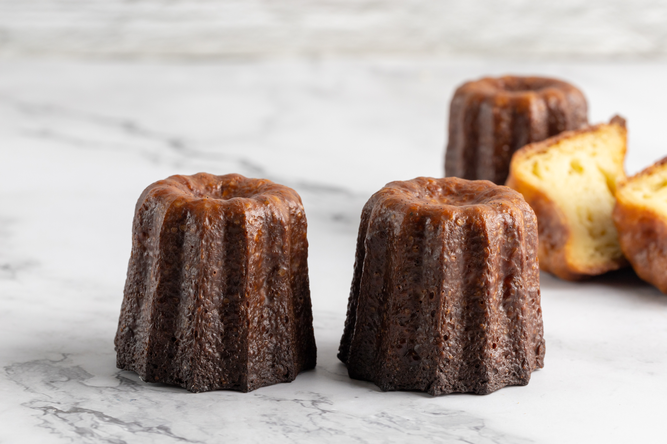 Canelés de Bordeaux by Sucré — dark caramelized exterior baked in copper molds