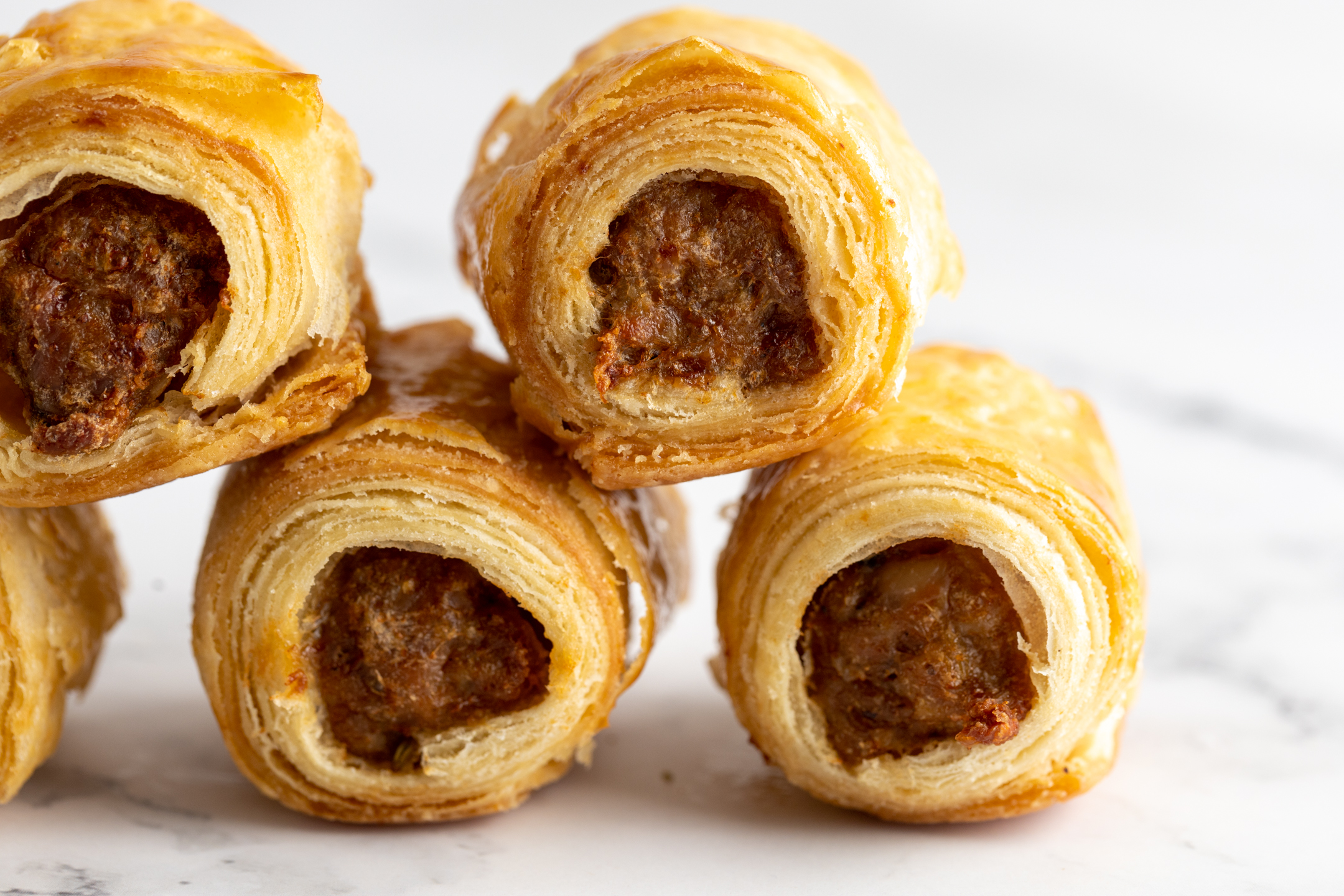 Mini Luxe Sausage Rolls cross-section showing hand-rolled all-butter pastry and seasoned sausage filling