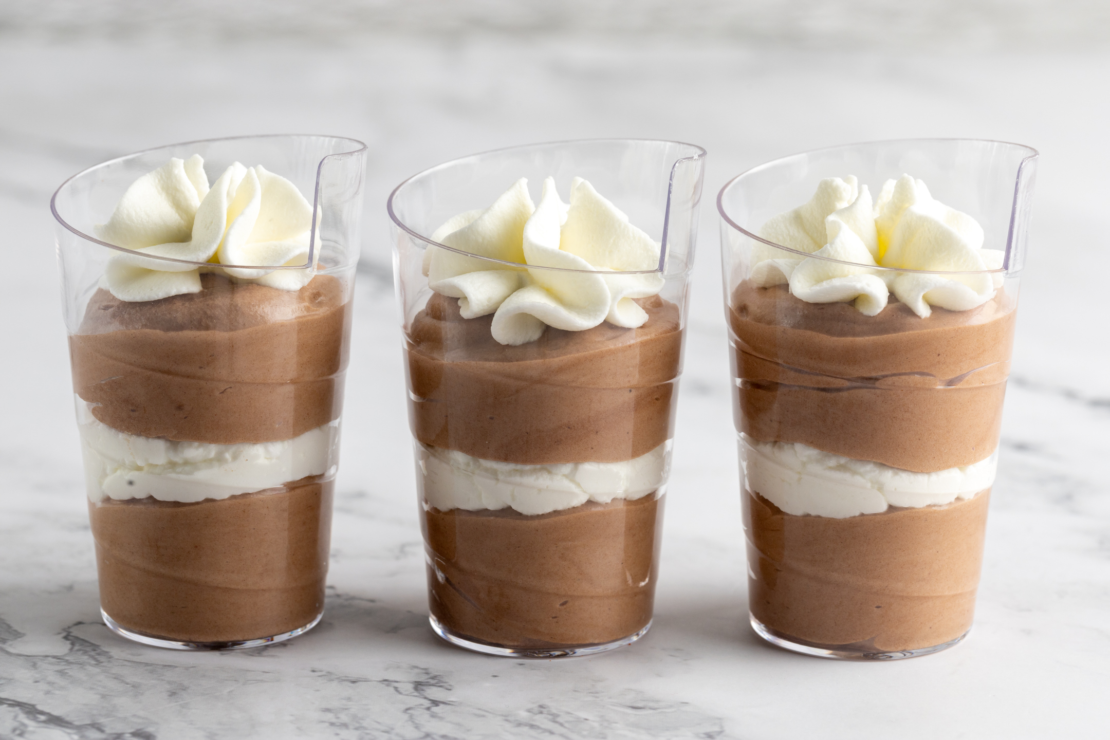 Belgian Couverture Chocolate Mousse Shooters in clear 2 oz glasses topped with Chantilly cream