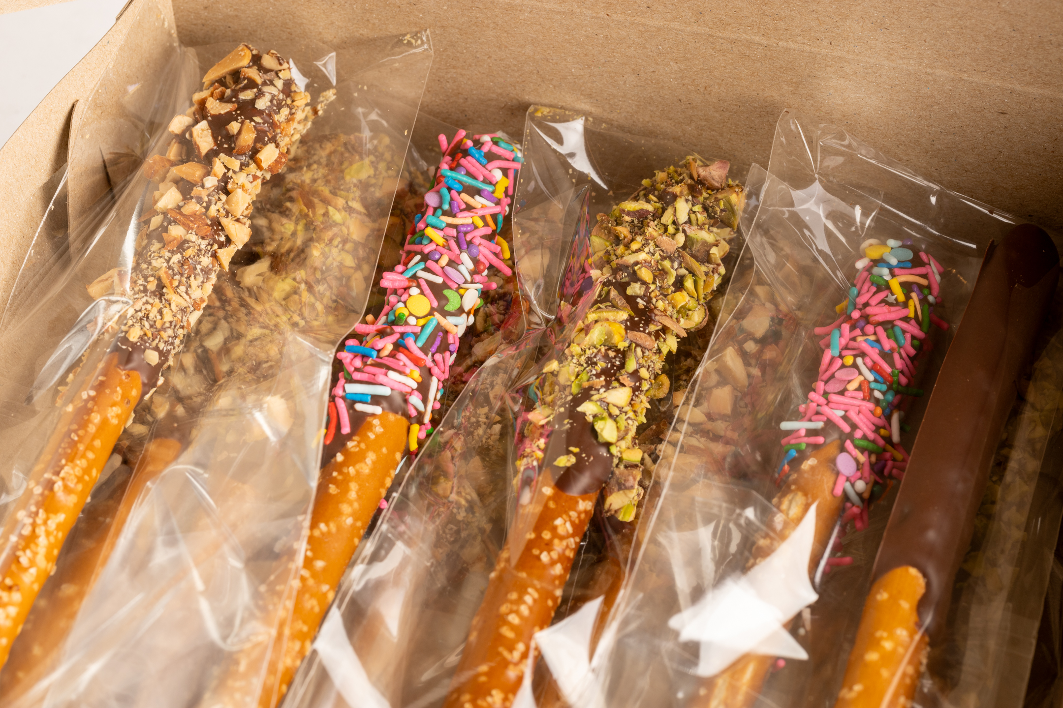 Assorted Belgian chocolate pretzel rods — plain, almond, pistachio and sprinkle varieties