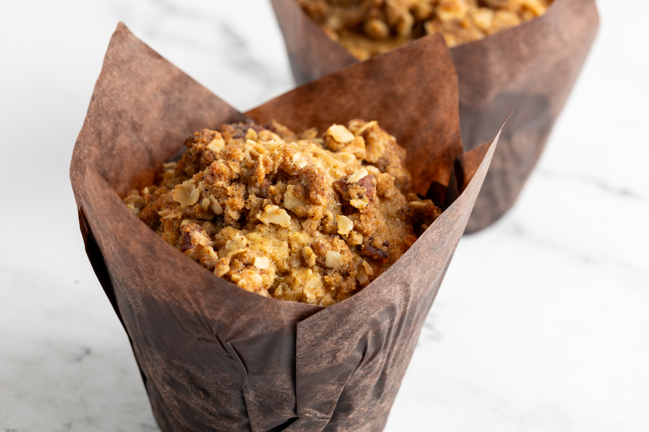 Tray of Oat Pecan Delight Muffins with dark brown sugar crumble tops by Sucré