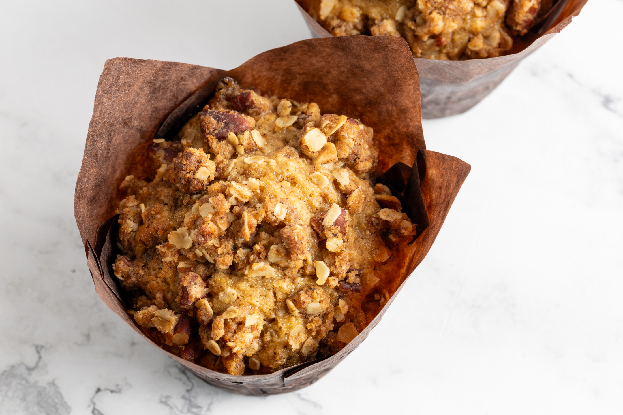 Oat Pecan Muffin close-up showing crunchy brown sugar crumble and pecan topping