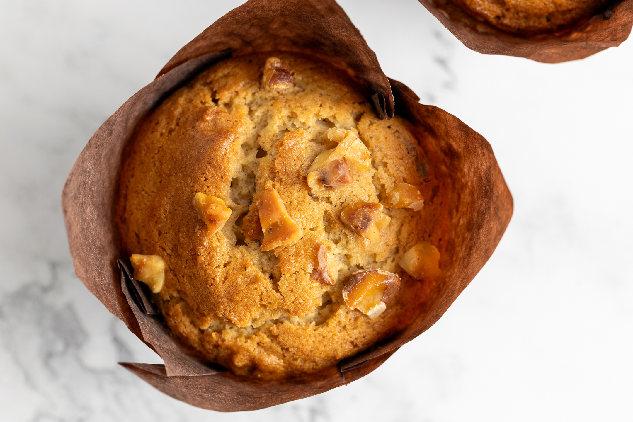 Spelt Walnut Maple Muffin close-up showing de-skinned roasted walnut topping