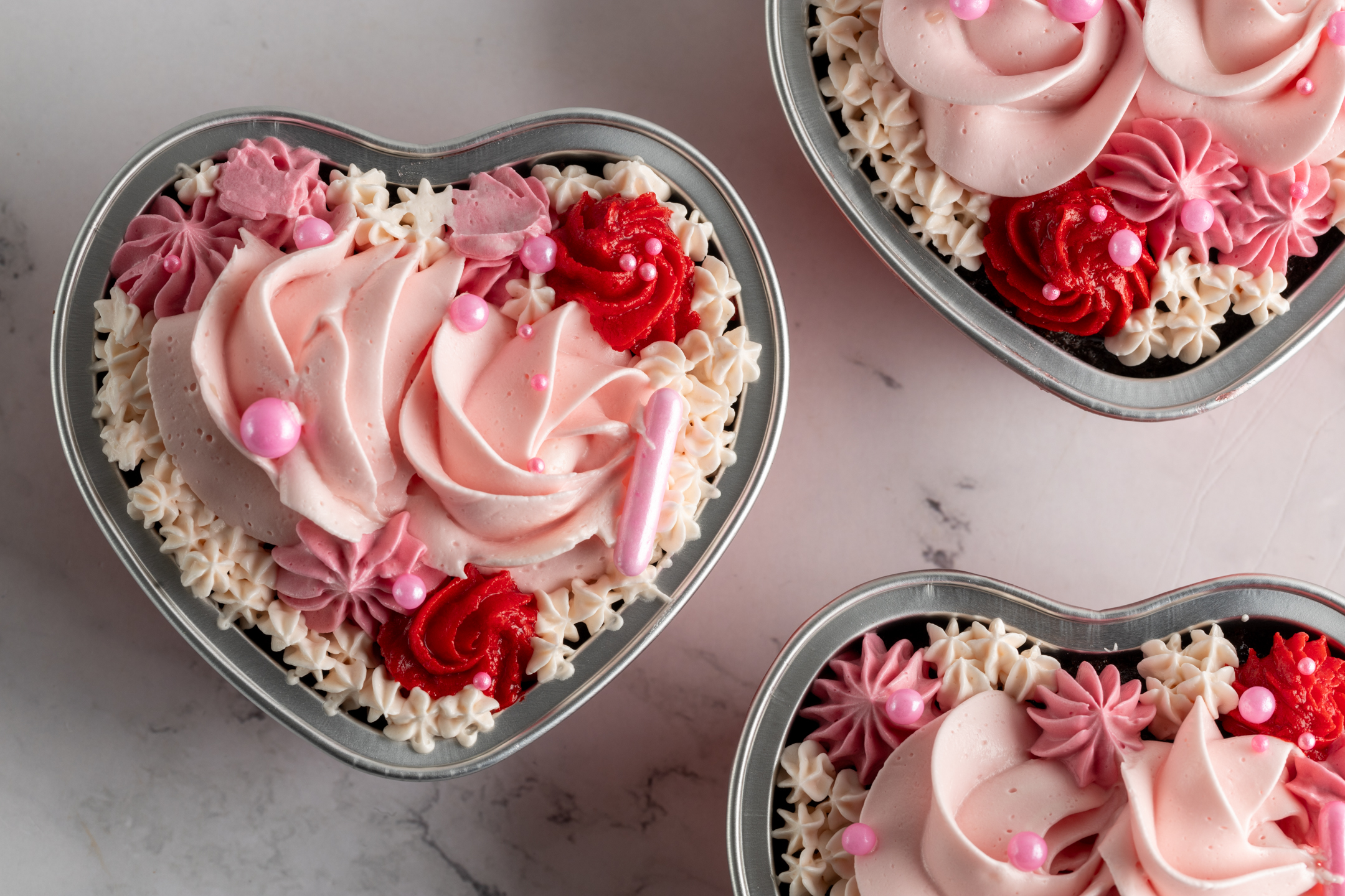 Sucré Petit Heart — heart-shaped chocolate cake with Italian meringue buttercream rosettes in red heart-shaped container